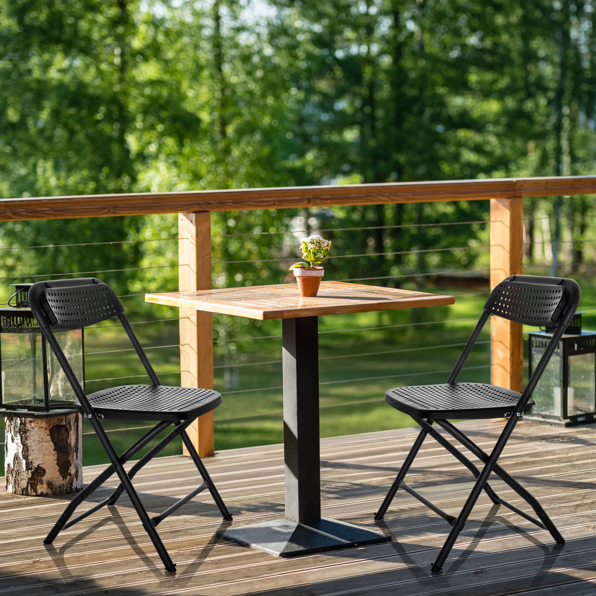Two black Outdoor chairs TUDELA XXL PRO with perforated seats at a wooden table by hjh OFFICE