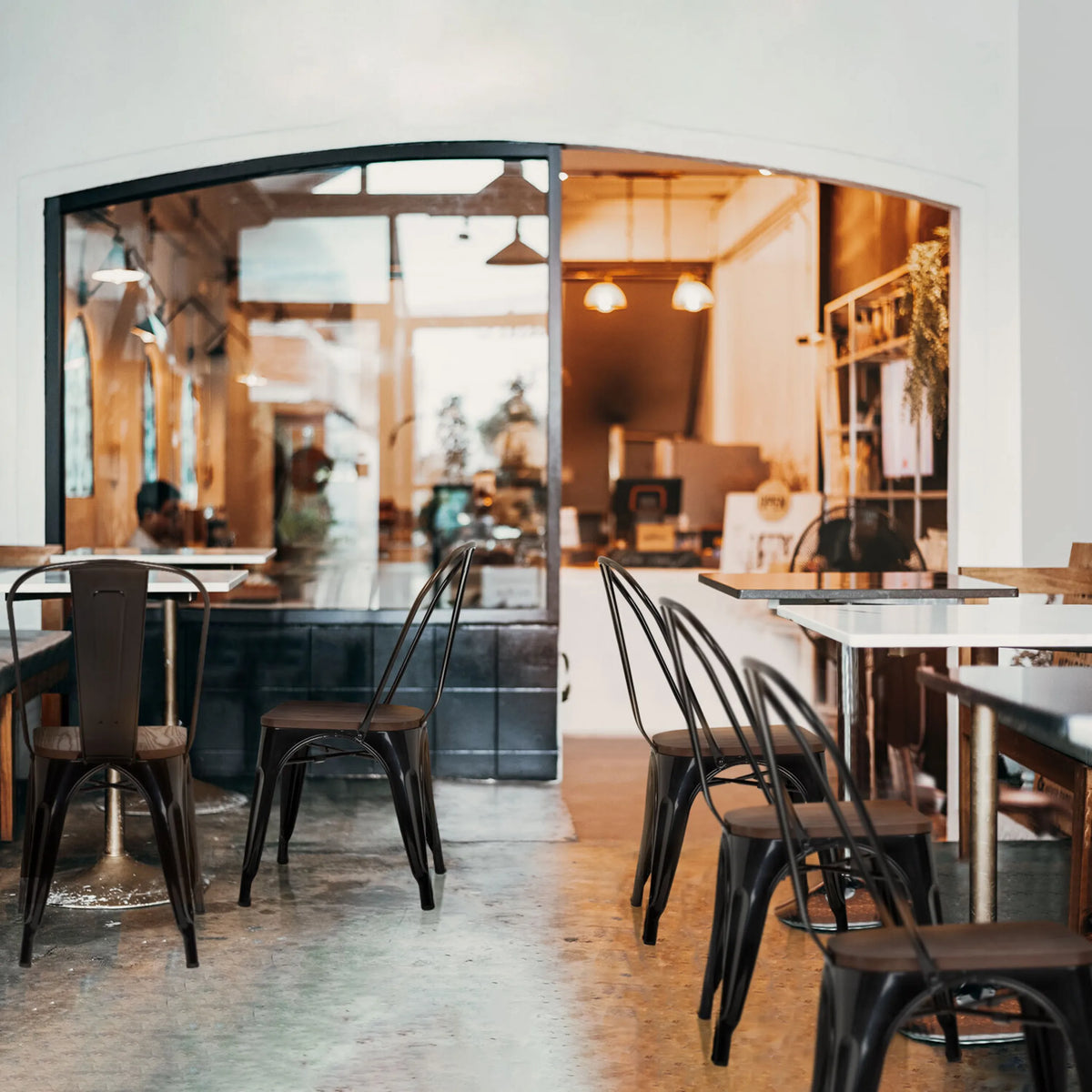 Black Bistro chairs VANTAGGIO COMFORT W with metal frames at tables in a café by hjh OFFICE