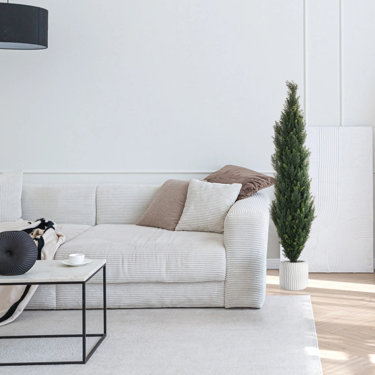 Green artificial plant CEDRUS in a white pot next to a white sofa by hjh OFFICE