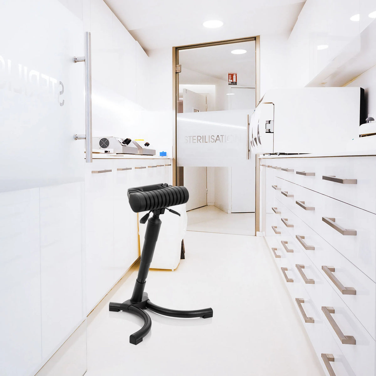 Black standing aid TOP WORK 33 with padded seat and star base in a bright sterilisation environment by hjh OFFICE