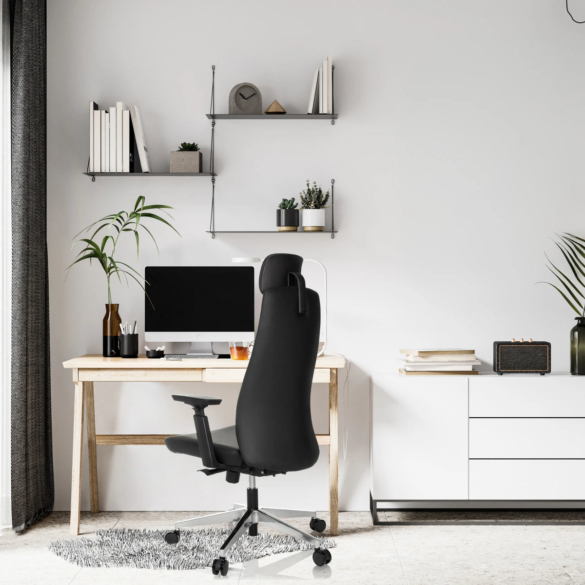 Black Professional Executive Chair YUCANO I at a desk in a bright room by hjh OFFICE