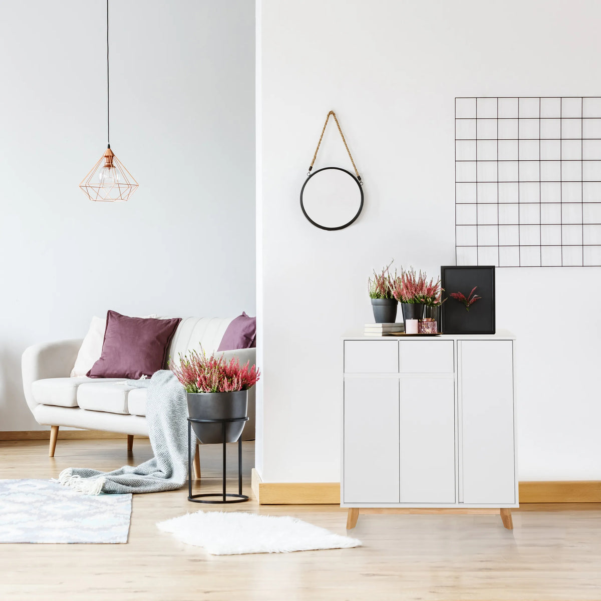 White chest of drawers ESTHA with two doors and light wood legs in a bright living room by hjh LIVING