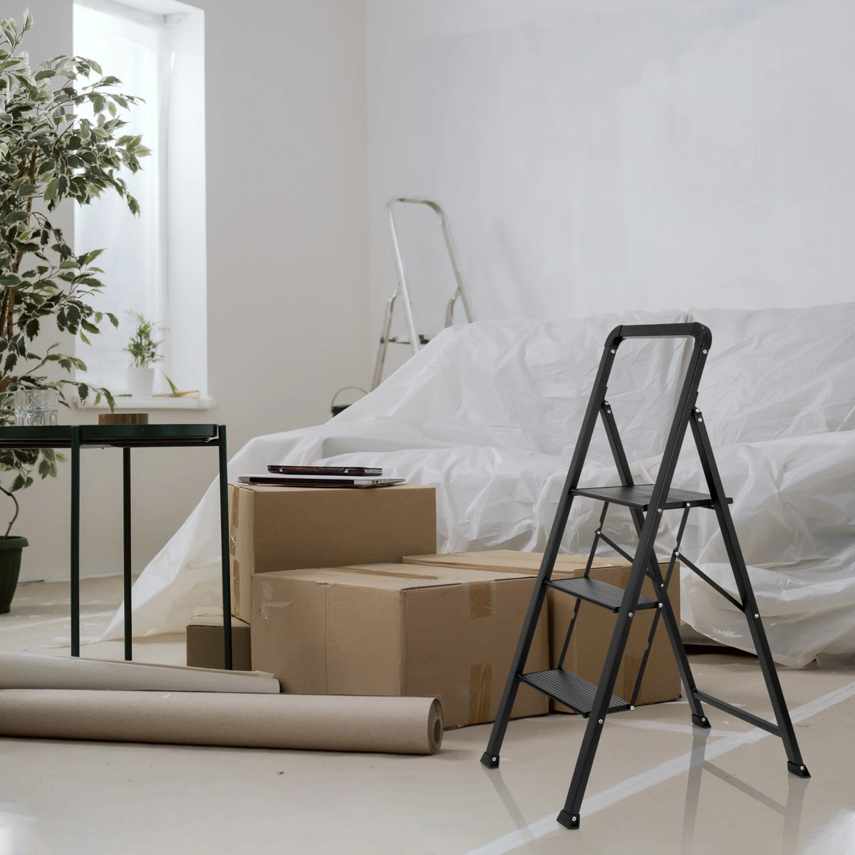 Black Folding Ladder SOLID W6 with three steps in a room next to moving boxes by hjh OFFICE