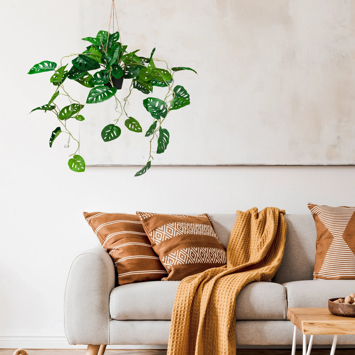 Green Artificial plant MONSTERA CLIMB as a hanging plant against a light wall by hjh OFFICE