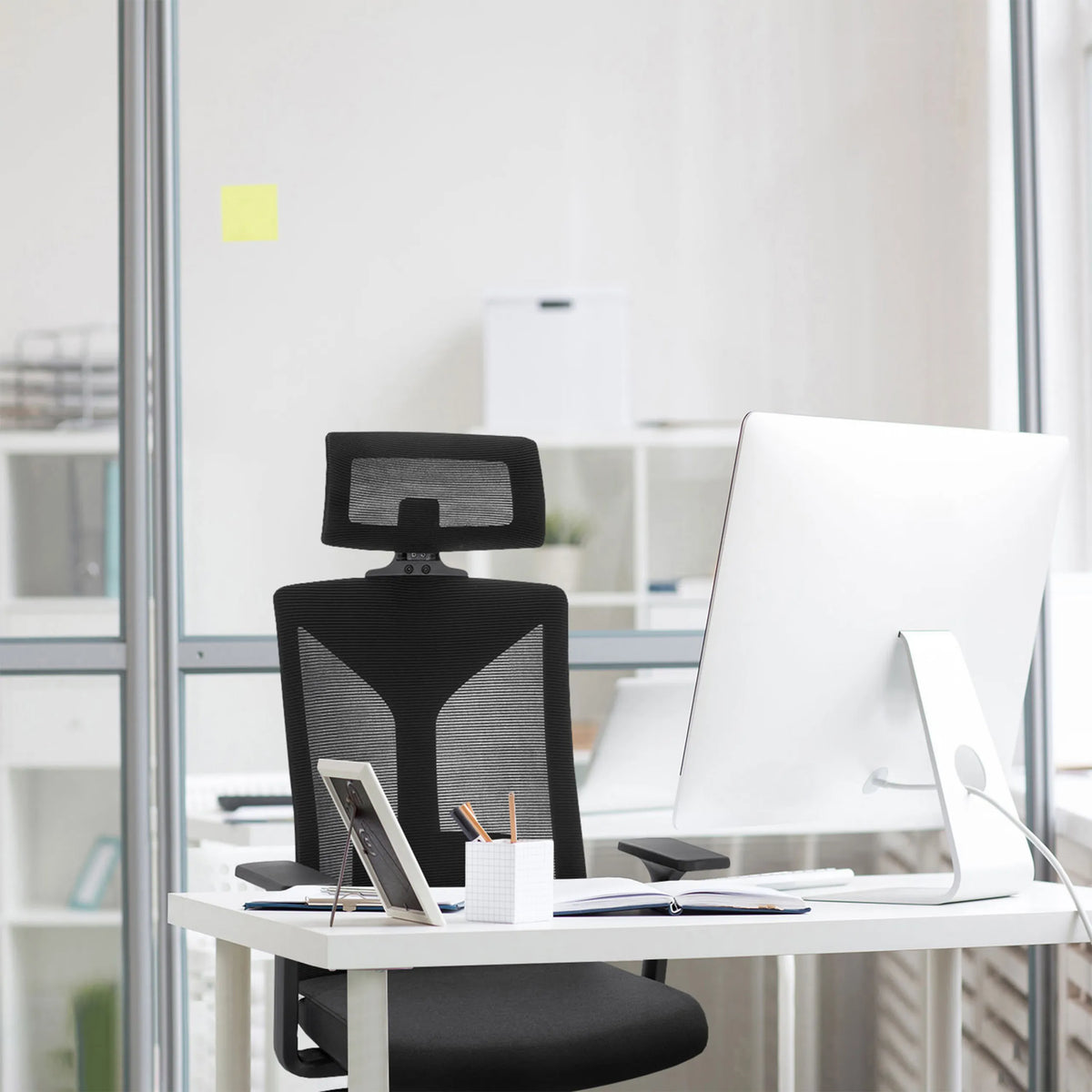 Black Professional Office Chair KODIAK with mesh backrest and headrest at a white desk by hjh OFFICE