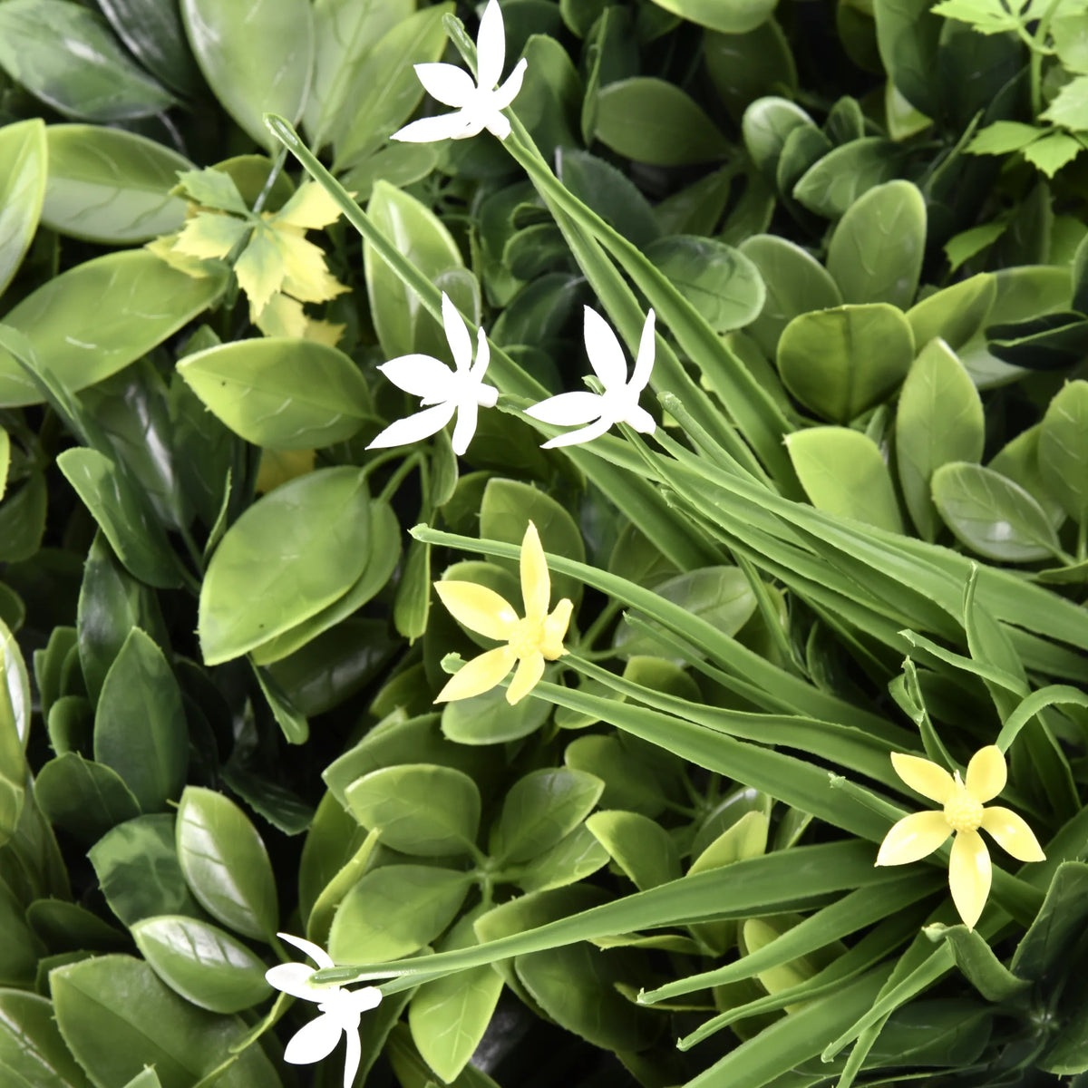 Green leaves with small white and yellow flowers of the Plant mat LEAFLUXE WALL 2 by hjh LIVING