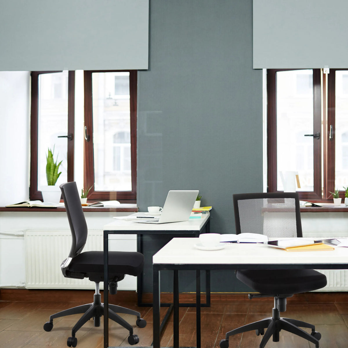 Two black Professional Office Chairs PORTO ECO at white desks in an office by hjh OFFICE