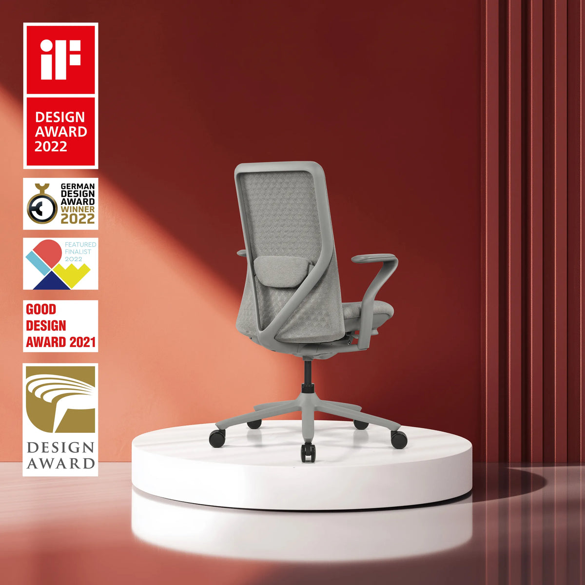 Grey high end office chair VERVIO with mesh backrest on a white plinth against a red background by hjh OFFICE
