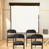 Four black TUDELA folding chairs in a room in front of a white projection screen by hjh OFFICE