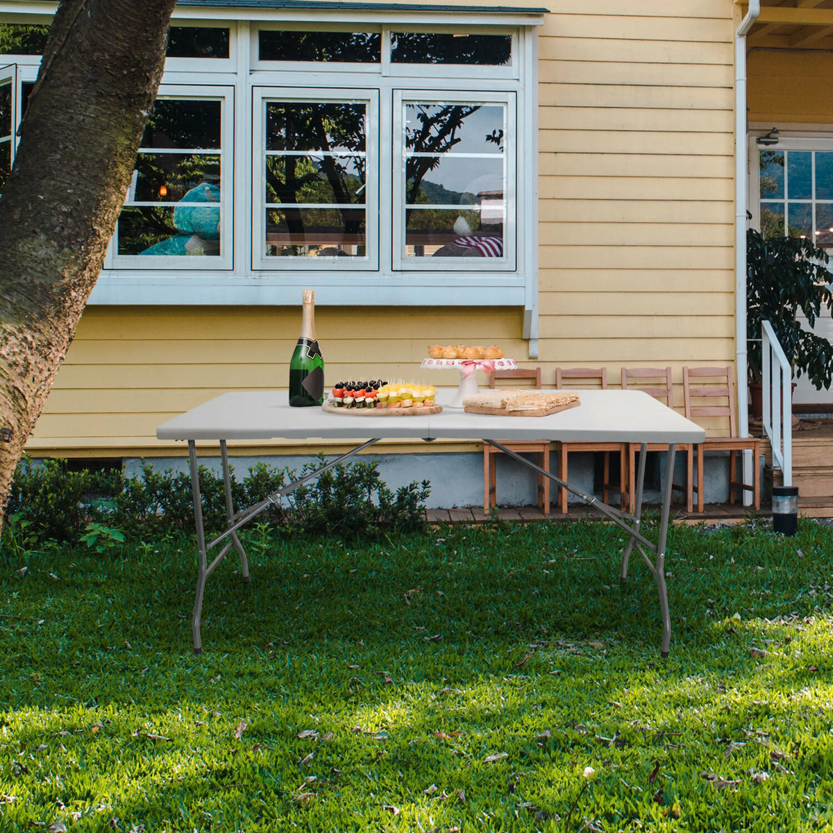 White Folding table EASY UP MULTI II, 152 x 70 cm, on a lawn in front of a house by hjh OFFICE