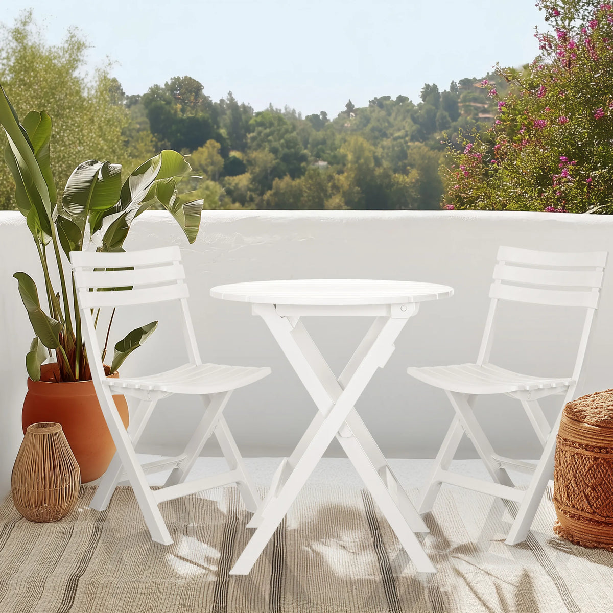 White folding table TRAVANO T with two matching folding chairs on a terrace by hjh LIVING
