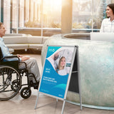 Poster stand AGENDA II made of aluminium with an advertising poster in a reception area by hjh OFFICE