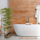 Green artificial plant BAMBUS I in a dark wooden box in front of a wall of wooden panels by hjh OFFICE