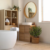 Green artificial plant Olive S in a woven basket next to a bathroom furniture piece by hjh OFFICE
