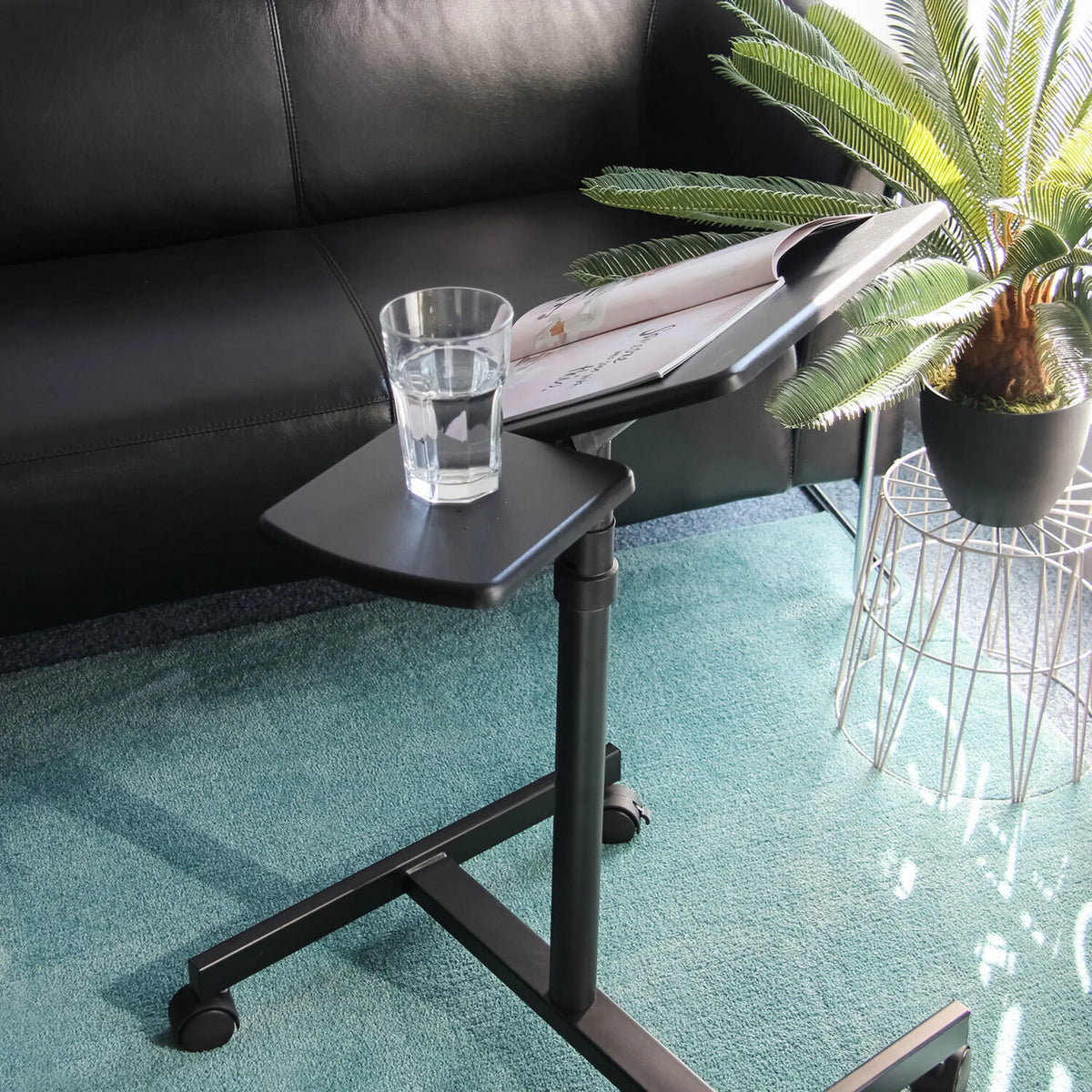 Black surface of the VM-SL standing desk with a glass and a magazine on a carpet by hjh OFFICE