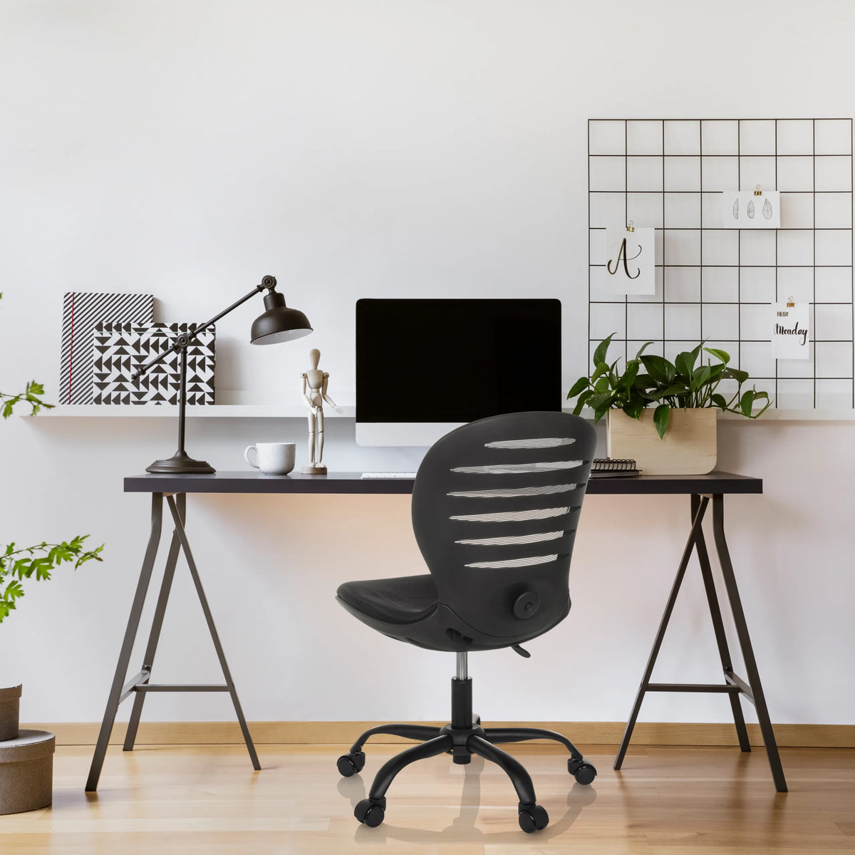 Black CASLA home office chair with a curved backrest and castors in front of a desk by hjh OFFICE