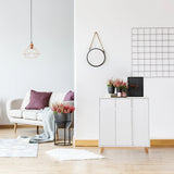 White chest of drawers ESTHA with two doors and light wood legs in a bright living room by hjh LIVING