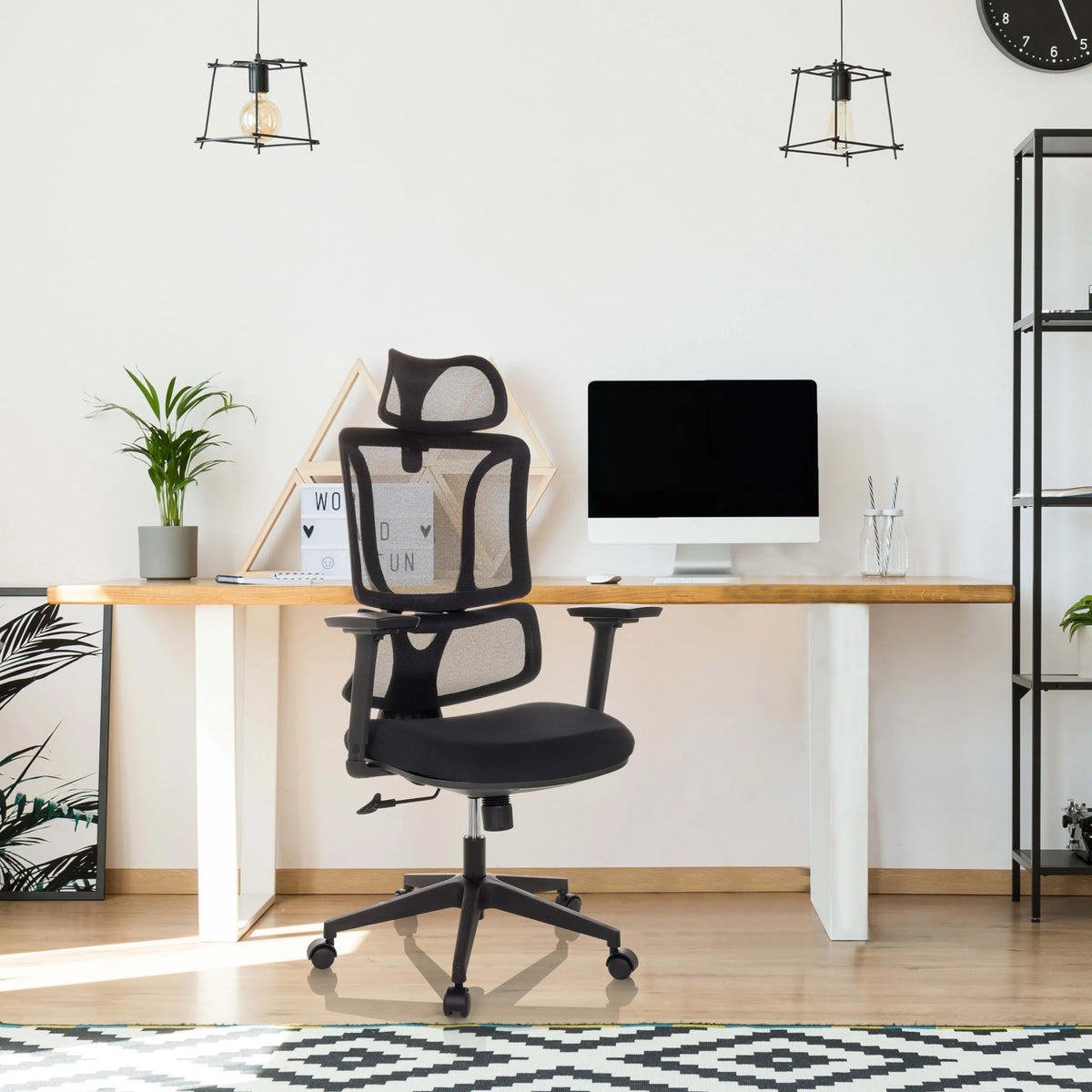 Black ERGOMY home office chair with mesh backrest and armrests at a desk by MyBuero