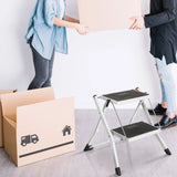 White folding ladder SOLID W1 with two black steps next to a moving box by hjh OFFICE