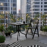 Black TRAVANO T1 folding table measuring 79 × 79 cm on a balcony by hjh LIVING (AI-generated image)