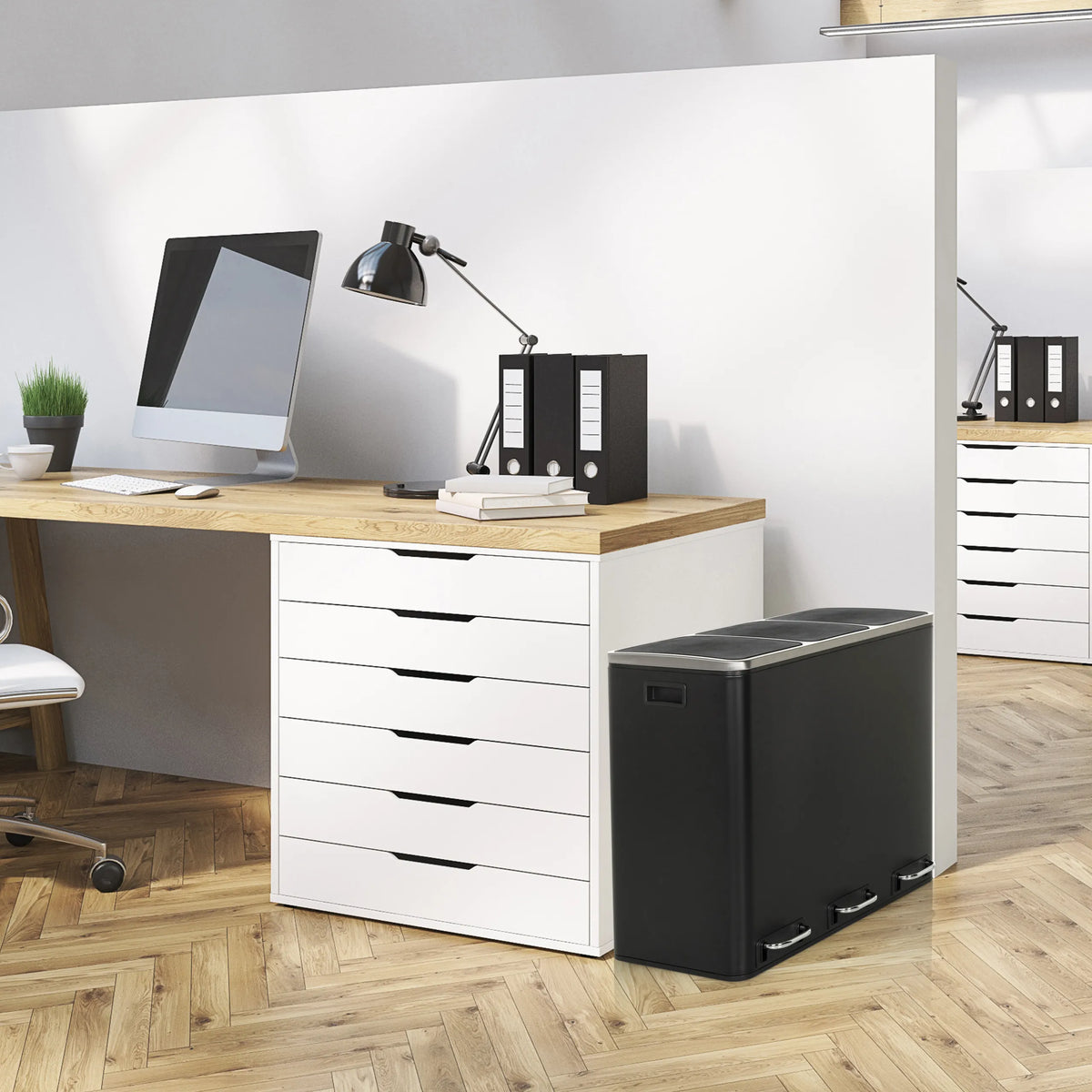 Black Wastepaper Clean 9 with two compartments next to a desk by hjh OFFICE