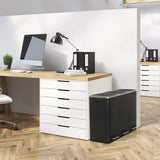 Black Wastepaper Clean 9 with two compartments next to a desk by hjh OFFICE
