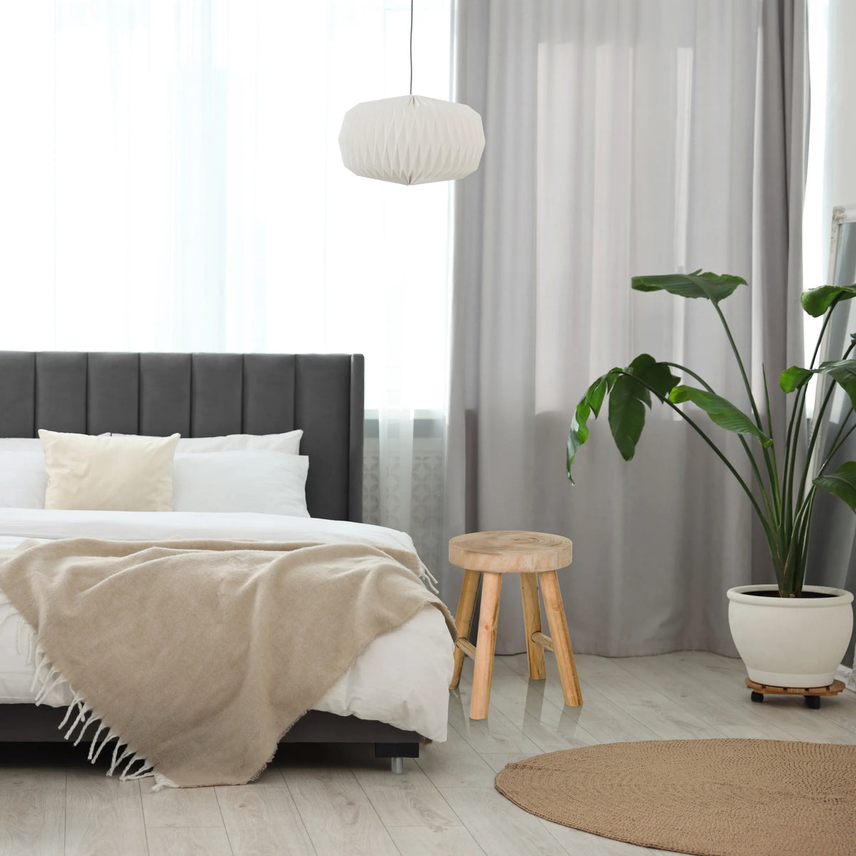 Brown wooden stool RUSTIKO W with three legs next to a bed by hjh LIVING