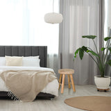 Brown wooden stool RUSTIKO W with three legs next to a bed by hjh LIVING