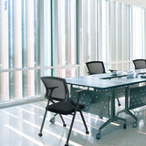 Folding chair PRIORITY II in black with mesh backrest at a conference table by hjh OFFICE