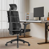 Black Professional Office Chair SPINIO PRO with headrest and armrests in front of a desk by hjh OFFICE