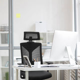Black Professional Office Chair KODIAK with mesh backrest and headrest at a white desk by hjh OFFICE