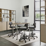 Four dark grey TOP WORK 40 work chairs with armrests and footrings at a white desk by hjh OFFICE
