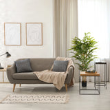 Green artificial plant BAMBUS II in a black pot next to a sofa by hjh OFFICE